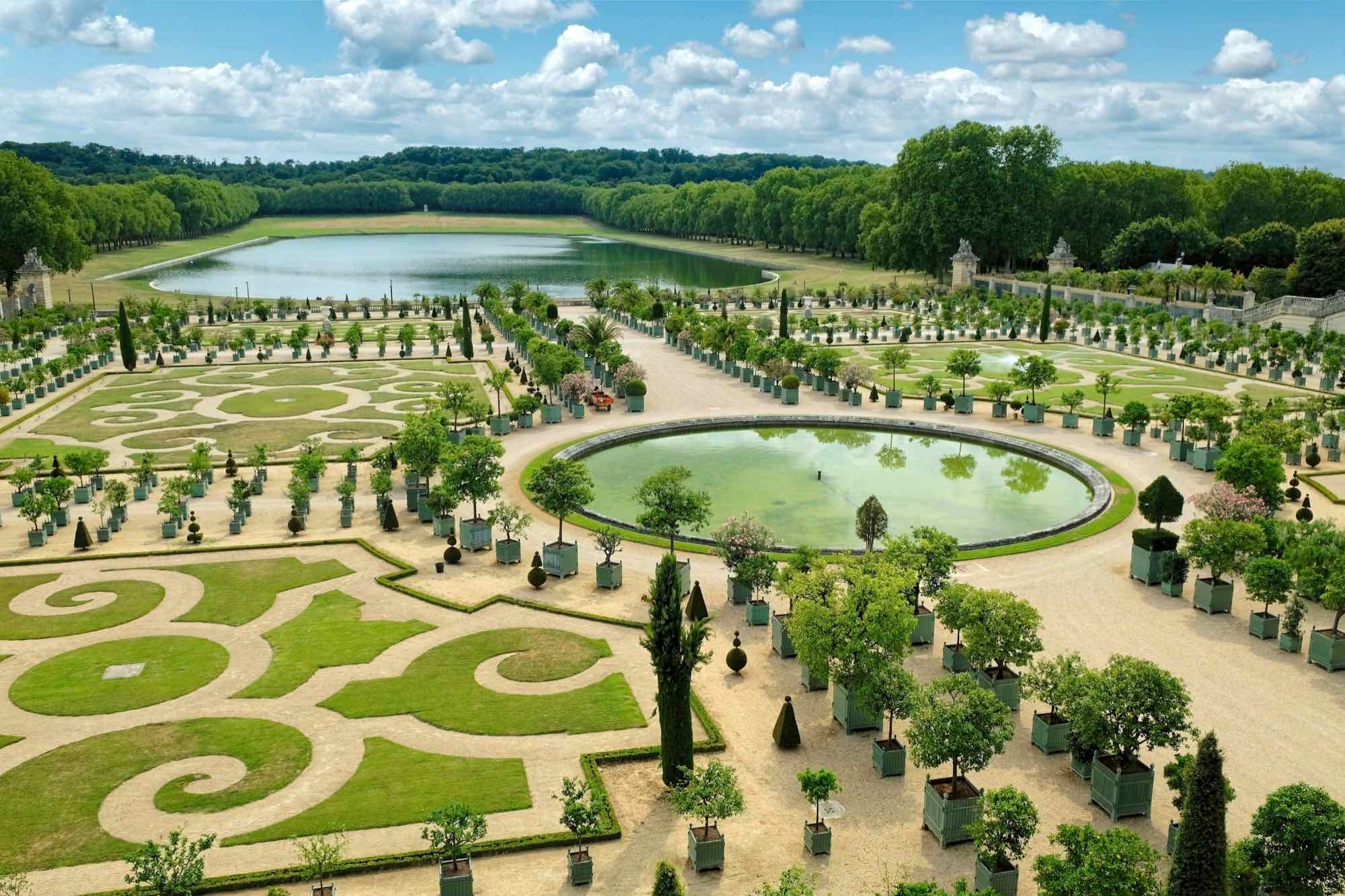 The Orangerie parterre at Versailles, with its swirling lawns, orange trees in planters and the great lake beyond